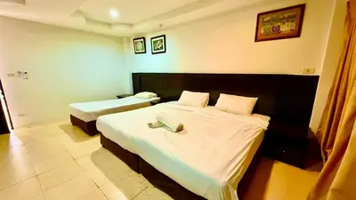 a hotel room with two beds with white sheets at Hill Side Patong Hotel in Patong Beach