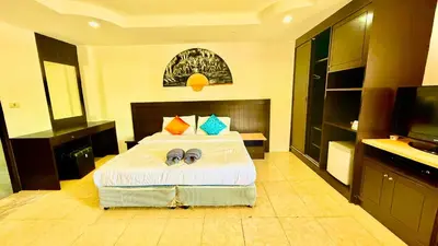 a bedroom with a bed and a flat screen tv at Hill Side Patong Hotel in Patong Beach