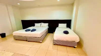 two beds sitting next to each other in a room at Hill Side Patong Hotel in Patong Beach