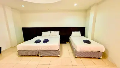 two beds sitting next to each other in a room at Hill Side Patong Hotel in Patong Beach