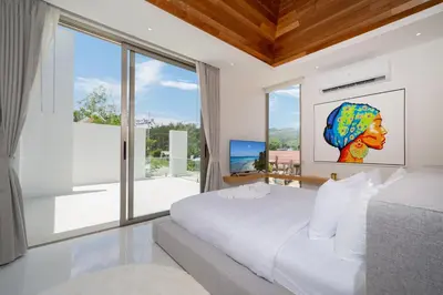 a bedroom with a bed and a large window at Exclusive 4BR Pool Designer Villa in Lux Pride 2 V6 Residence, Near Laguna in Bang Tao Beach
