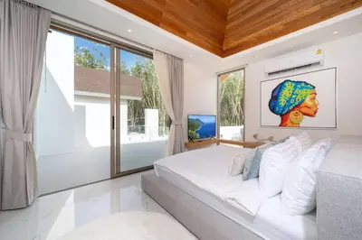 a bedroom with a white bed and large windows at New Build Masterpiece with Private Pool - 4BR Villa in Lux Pride 2 V7 Residence in Bang Tao Beach