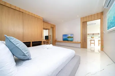 a bedroom with a large white bed with a couch at New Build Masterpiece with Private Pool - 4BR Villa in Lux Pride 2 V7 Residence in Bang Tao Beach