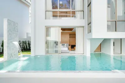 a house with a swimming pool in front of a building at Your Private Piece of Paradise! 4BR Pool Villa in the New Lux Pride 2 V9 Residence in Bang Tao Beach