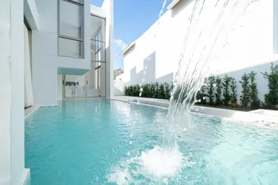 a water fountain in a swimming pool in a building at Your Private Piece of Paradise! 4BR Pool Villa in the New Lux Pride 2 V9 Residence in Bang Tao Beach