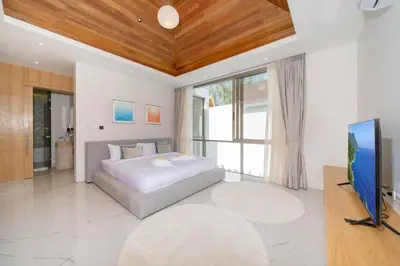 a bedroom with a bed and a flat screen tv at Modern Elegance & Tropical Vibe - 4BR Pool Villa in New Build Residence Lux Pride 2 V10 in Bang Tao Beach
