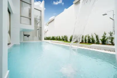 a swimming pool in a house with a water feature at Exclusive Living in Designer 4BR Pool Villa in Lux Pride 2 V11 Residence, Near Laguna in Bang Tao Beach