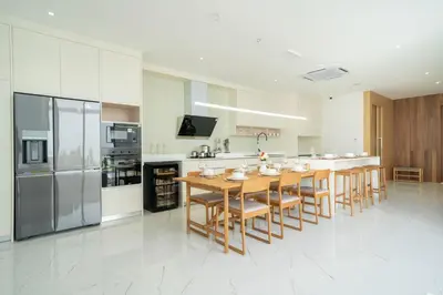 a large kitchen with a wooden table and chairs at Exclusive Living in Designer 4BR Pool Villa in Lux Pride 2 V11 Residence, Near Laguna in Bang Tao Beach