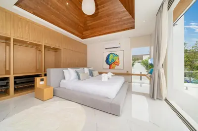 a bedroom with a white bed and a large window at Exclusive Living in Designer 4BR Pool Villa in Lux Pride 2 V11 Residence, Near Laguna in Bang Tao Beach