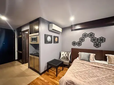 a bedroom with a bed and a chair at Cozy studio near Bangtao Beach in Bang Tao Beach