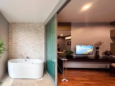 a bathroom with a tub and a tv in a room at Cozy studio near Bangtao Beach in Bang Tao Beach