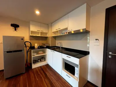 a kitchen with white cabinets and a stainless steel refrigerator at Title III Condo Rawai, 1 bedroom in Phuket Town