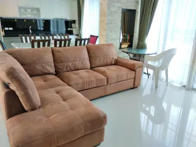a living room with a brown couch and a table at Luxury spacious 3 bdr apartment Pandora residence in Nai Harn Beach