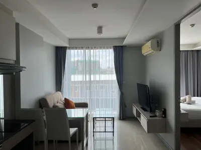 a living room with a couch and a table with a television at Condo Surin-Bangtao Beach in Surin Beach