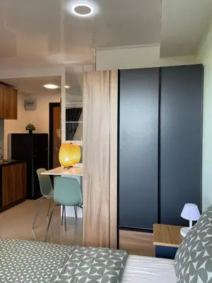 a bedroom with a bed and a table with chairs at Skyline Retreat in Ban Mai Salae