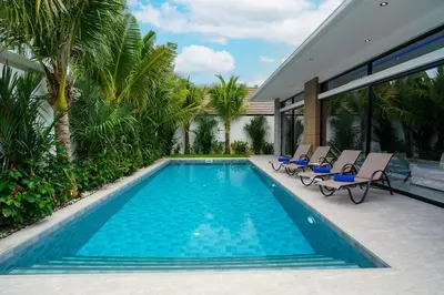 a swimming pool with chairs and a house at Diamond 1 Villa by G Estate Phuket in Ban Saiyuan (1)