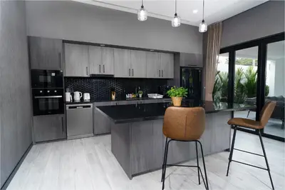 a kitchen with a counter and chairs in a room at Diamond 1 Villa by G Estate Phuket in Ban Saiyuan (1)