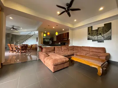 a living room with a brown couch and a table at Вилла в сердце Пхукета in Surin Beach