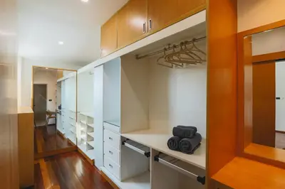 a walk in closet with white cabinets and wood floors at Summer Villa Patong in Patong Beach