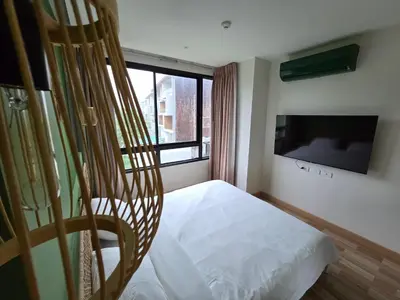 a bedroom with a bed and a flat screen tv at Beachside Gem with Lake, Cafes and more in Rawai Beach