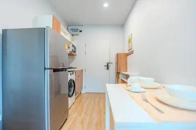 a kitchen with a refrigerator and a table with plates at ZcapeX2 94-18 by Silqstay in Thalang