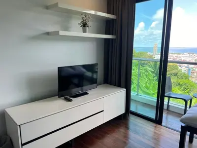 a living room with a television on a white dresser at Thebirdhouse Patong Phuket103 in Patong Beach
