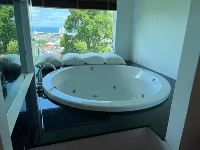 a bath tub in a room with a large window at Thebirdhouse Patong Phuket103 in Patong Beach