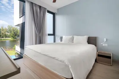 a bedroom with a large bed and a large window at Cassia Residences in Laguna by Banyan Living in Laguna Phuket