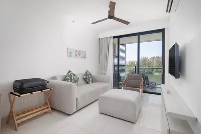 a living room with a couch and a tv at Cassia Residences in Laguna by Banyan Living in Laguna Phuket