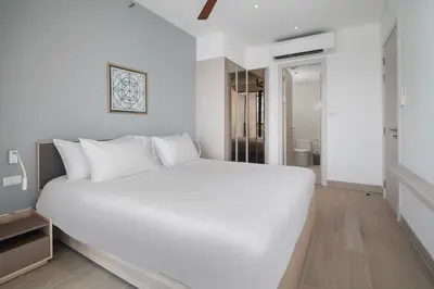 a white bedroom with a large white bed in it at Cassia Residences in Laguna by Banyan Living in Laguna Phuket