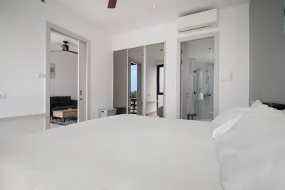 a bedroom with a bed and a large mirror at Cassia Residences in Laguna by Banyan Living in Laguna Phuket