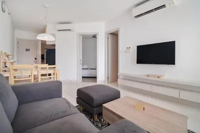 a living room with a couch and a tv on a wall at Cassia Residences in Laguna by Banyan Living in Laguna Phuket