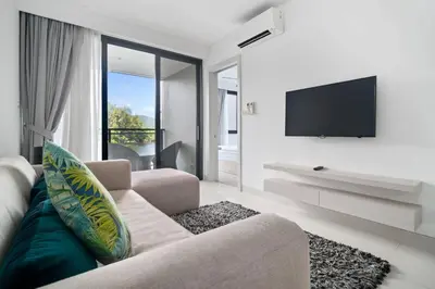 a living room with a couch and a flat screen tv at Cassia Residences in Laguna by Banyan Living in Laguna Phuket