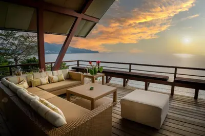 a living room with a couch and a view of the ocean at Laemsingh Villa 1 - Luxury Villa 5 Bedrooms in Surin Beach