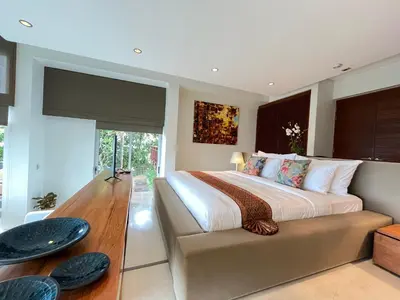 a bedroom with a large bed and a table at Laemsingh Villa 1 - Luxury Villa 5 Bedrooms in Surin Beach