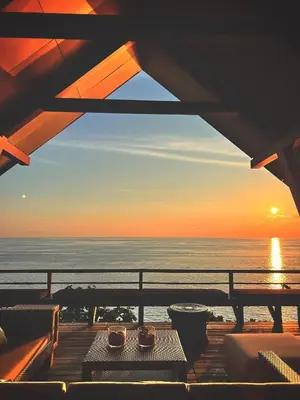 a view of the ocean from a deck at sunset at Laemsingh Villa 1 - Luxury Villa 5 Bedrooms in Surin Beach
