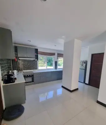 a large kitchen with a white floor and appliances at Jungle Pool Villa in Chalong in Changwat Phuket
