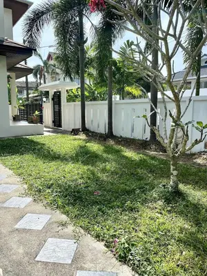 a backyard of a house with a fence and a tree at Jungle Pool Villa in Chalong in Changwat Phuket