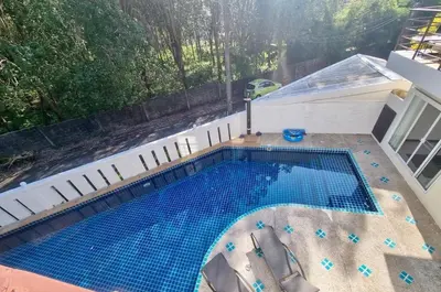 a large swimming pool with two chairs next to it at Jungle Pool Villa in Chalong in Changwat Phuket