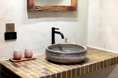 a bathroom with a sink with a large wheeluilt at Ḥokma Boutique Hotel & Tropical Lounge in Phi Phi Don
