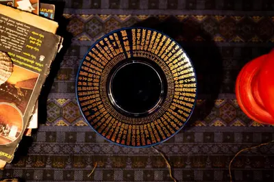 a plate sitting on top of a table with a book at Ḥokma Boutique Hotel & Tropical Lounge in Phi Phi Don