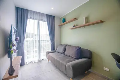 a living room with a couch and a large window at Thai Me Up the Tower in Ban Klang