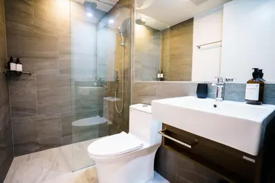 a bathroom with a toilet and a sink and a shower at Thai Me Up the Tower in Ban Klang