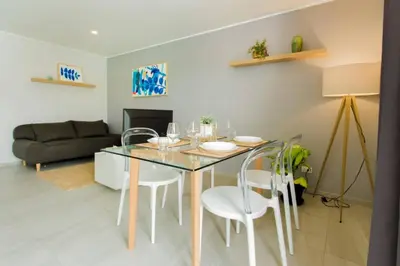a dining room with a glass table and white chairs at Thai Me Up the Tower in Ban Klang