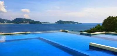 a large swimming pool with a view of the water at Luxurious 5 Bedroom Condo, private pool, in Patong with Seaview in Patong Beach