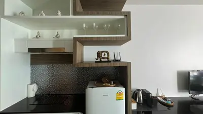 a kitchen with a refrigerator and shelves with wine glasses at The Regent Bangtao Spacious and comfortable studio at Bang Tao area in Bang Tao Beach