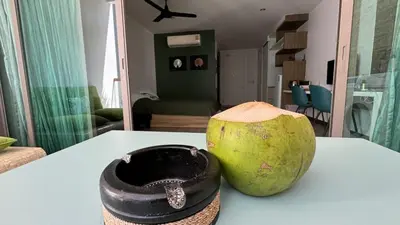 a coconut sitting on a table in a living room at The Regent Bangtao Spacious and comfortable studio at Bang Tao area in Bang Tao Beach