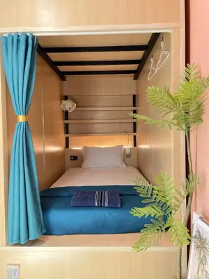 a bed in a small room with a blue canopy at Plearn Phuket Boutique Hostel in Ban Lo Long