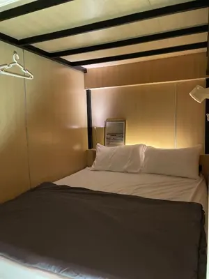 a bed with white pillows in a room at Plearn Phuket Boutique Hostel in Ban Lo Long