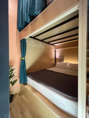 a bedroom with a bunk bed with blue curtains at Plearn Phuket Boutique Hostel in Ban Lo Long